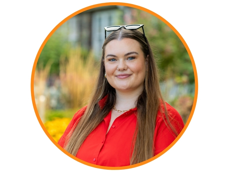 Caitlin Breen Airfield Estate Smiling girl with glasses on head wearing a red shirt
