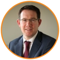 Joseph Higgins Guinness Storehouse Man with brown hair wearing glasses and suit and tie smiling